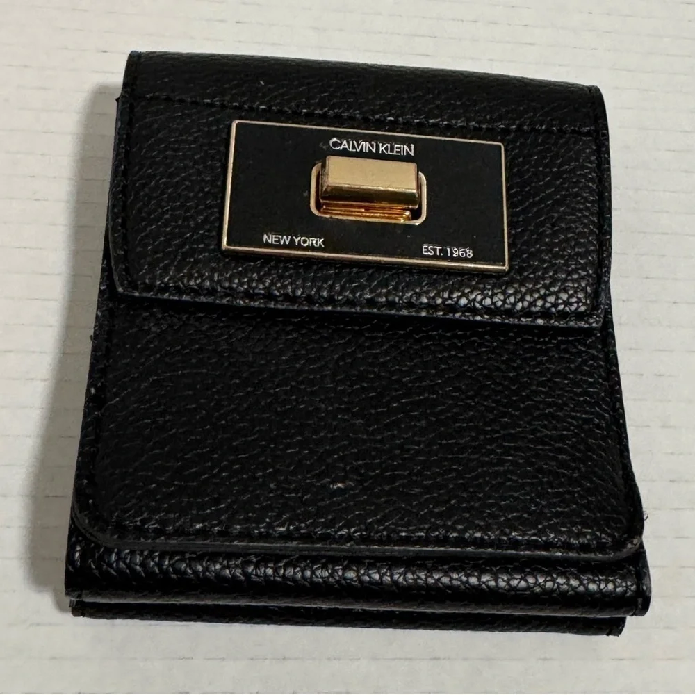 Calvin Klein black trifold wallet with a gold-tone metal closure